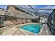 A view of the enclosed pool with brick pavers and a screened enclosure providing privacy at 1 Fox Hollow Dr, Ormond Beach, FL 32174