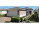 Charming home showcasing a well-manicured lawn, brick driveway and a two-car garage with dark sconces at 1088 Avery Meadows Way, Deland, FL 32724