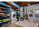 Basement laundry area with two modern washing machines, shelving and storage at 111 Claire Ter, Daytona Beach, FL 32118