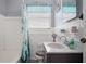 Nautical themed bathroom features white tiled walls, vanity sink and shower with themed curtain at 111 Claire Ter, Daytona Beach, FL 32118