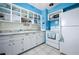 Bright kitchen featuring white cabinets, tile backsplash, marble countertops, and open shelving for ample storage at 111 Claire Ter, Daytona Beach, FL 32118