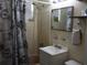 Bathroom area with a vanity, floral shower curtain, and classic tile work at 1151 Deltona Blvd, Deltona, FL 32725