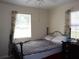 Cozy bedroom with a black metal bed frame and bright natural light from two windows at 1151 Deltona Blvd, Deltona, FL 32725