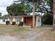 Modest single story home featuring shuttered windows, a front porch and mature landscaping at 1151 Deltona Blvd, Deltona, FL 32725