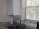 Close-up of the kitchen sink with stone countertops and white cabinets at 1151 Deltona Blvd, Deltona, FL 32725