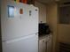 View of kitchen amenities including white fridge, cabinets, and granite countertops at 1151 Deltona Blvd, Deltona, FL 32725