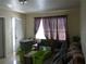 Living room with neutral color palette, sofa, plants, and storage bins at 1151 Deltona Blvd, Deltona, FL 32725