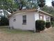 Home exterior, side view, showing windows and utilities, next to mature landscaping at 1151 Deltona Blvd, Deltona, FL 32725