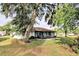 A well-maintained backyard featuring a screened-in patio, lush lawn, and mature trees for shade at 1167 Peachtree Rd, Daytona Beach, FL 32114