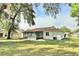 A view of the home's backyard, complete with screened-in patio and ample green space at 1167 Peachtree Rd, Daytona Beach, FL 32114