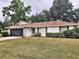 Charming single-story home with mature trees, manicured lawn, and attached two car garage at 1167 Peachtree Rd, Daytona Beach, FL 32114