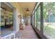 Relaxing screened patio with tile flooring, ceiling fan, and serene views at 120 Hibiscus Woods Ct # 2A, Deltona, FL 32725