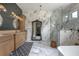 A luxury bathroom featuring marble tile, a walk-in shower, soaker tub and a large decorative mirror at 125 Smyrna Dr, Debary, FL 32713