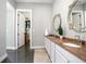 Bright bathroom featuring a double vanity with granite countertops and decorative mirrors at 125 Smyrna Dr, Debary, FL 32713