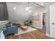 Upstairs bonus room has a vaulted ceiling, dark sofa, wood floors, and a hall door at 125 Smyrna Dr, Debary, FL 32713