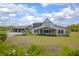 Charming home exterior with a well-manicured lawn, covered porch, and three car garage at 125 Smyrna Dr, Debary, FL 32713