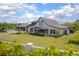 Beautiful home exterior with a well-manicured lawn, covered porch, and three car garage at 125 Smyrna Dr, Debary, FL 32713