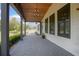 Covered front porch with a custom light fixture, brick flooring, and views of the front yard at 125 Smyrna Dr, Debary, FL 32713