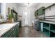 A modern laundry room with custom green cabinets, countertop space and a washer and dryer set at 125 Smyrna Dr, Debary, FL 32713