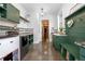 Beautifully finished laundry room with green cabinets, counter space, and a bench and storage area at 125 Smyrna Dr, Debary, FL 32713