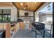 Outdoor kitchen with stainless steel grill, wooden cabinetry, and stylish lighting at 125 Smyrna Dr, Debary, FL 32713