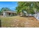Spacious backyard with a screened lanai, mature trees, and white fencing at 1253 Bramley Ln, Deland, FL 32720