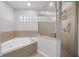 Spa-like bathroom with a soaking tub, glass-enclosed shower, and decorative tile at 1253 Bramley Ln, Deland, FL 32720