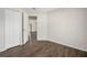 This empty room has wood floors, white trim, and a view into the hallway at 1253 Bramley Ln, Deland, FL 32720