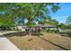Charming single-story home with a well-manicured front yard and mature trees on a sunny day at 1253 Bramley Ln, Deland, FL 32720