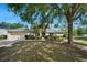 Charming single-story home with mature trees and a well-manicured lawn on a sunny day at 1253 Bramley Ln, Deland, FL 32720