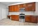Kitchen featuring stainless steel appliances, wood cabinets, and a built-in desk at 1253 Bramley Ln, Deland, FL 32720