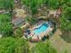 Aerial view of a community pool with lounge chairs surrounded by lush greenery at 1253 Bramley Ln, Deland, FL 32720