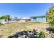 Large backyard with two homes, one light yellow and one light blue, under a clear blue sky at 130 Harrison Rd, Daytona Beach, FL 32118