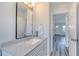 A modern bathroom featuring a white vanity, granite countertops, and views of the hallway and front door at 130 Harrison Rd, Daytona Beach, FL 32118