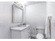 Well-lit powder room features a white vanity with marble countertop and decorative framed mirror at 130 Harrison Rd, Daytona Beach, FL 32118