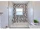 This neutral bathroom features modern tile and a shower head over the tub at 130 Harrison Rd, Daytona Beach, FL 32118