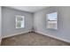This cozy bedroom features neutral carpeting and paint, plus natural light from two windows at 130 Harrison Rd, Daytona Beach, FL 32118