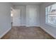 Empty bedroom with neutral carpet, two doors and a window at 130 Harrison Rd, Daytona Beach, FL 32118