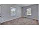 Empty bedroom with neutral carpet and natural light from two windows at 130 Harrison Rd, Daytona Beach, FL 32118