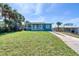 Charming single-story home with a well-manicured lawn, complemented by mature palm trees and a cozy front porch at 130 Harrison Rd, Daytona Beach, FL 32118