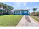 Charming home with a well-maintained lawn, a welcoming porch, and swaying palm trees for a relaxed coastal vibe at 130 Harrison Rd, Daytona Beach, FL 32118