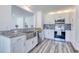 Modern kitchen featuring granite countertops, stainless appliances, and gray wood flooring, a culinary dream at 130 Harrison Rd, Daytona Beach, FL 32118
