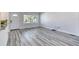 Bright living area features gray wood floors, large window, and neutral paint, creating a cozy atmosphere at 130 Harrison Rd, Daytona Beach, FL 32118