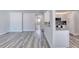 This living space includes gray wood flooring, fresh paint and a kitchen view at 130 Harrison Rd, Daytona Beach, FL 32118