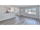Light-filled living room showcases stylish gray wood flooring and a view into the adjacent breakfast nook at 130 Harrison Rd, Daytona Beach, FL 32118