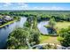 Scenic aerial view of the community featuring a peaceful lake, walking trails, and well-maintained landscaping at 13944 Huntwick Dr, Orlando, FL 32837