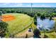 Aerial view of the baseball field and pond surrounded by lush greenery, offering a beautiful recreational space at 13944 Huntwick Dr, Orlando, FL 32837