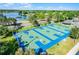 Aerial view of blue and green painted outdoor basketball courts with lake view surrounded by trees, perfect for active residents at 13944 Huntwick Dr, Orlando, FL 32837