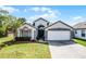 Charming single-story home with a well-manicured lawn, beautiful landscaping, and a two-car garage at 13944 Huntwick Dr, Orlando, FL 32837