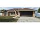Charming single-story brick home featuring a well-manicured lawn and a two-car garage at 1408 E Normandy Blvd, Deltona, FL 32725